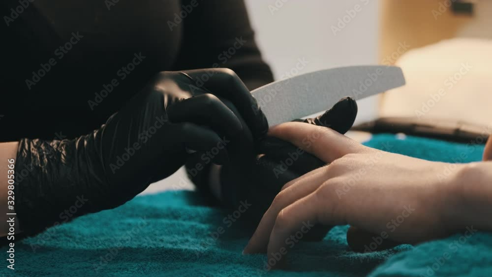 Men's manicure. Professional manicure for man by manicure machine. A man receiving a manicure in the beauty salon. Beautician master trimming and removes cuticles. Men's manicure. Professional manicure for man by manicure machine. A man receiving a manicure in the beauty salon. Beautician master trimming and removes cuticles.