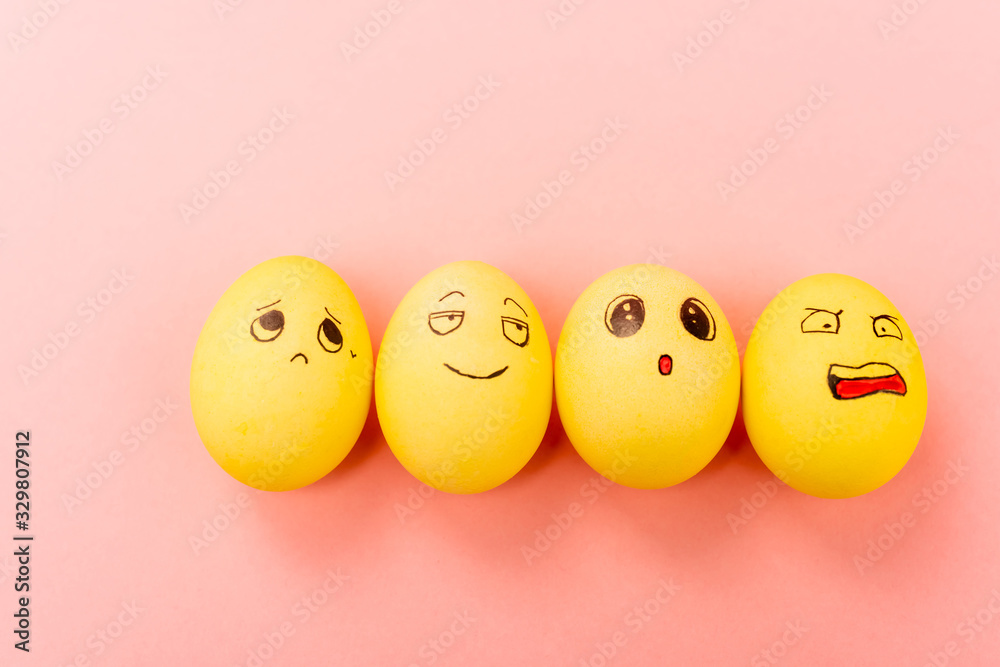 Top view of Easter eggs with different funny facial expressions on pink background Top view of Easter eggs with different funny facial expressions on pink background