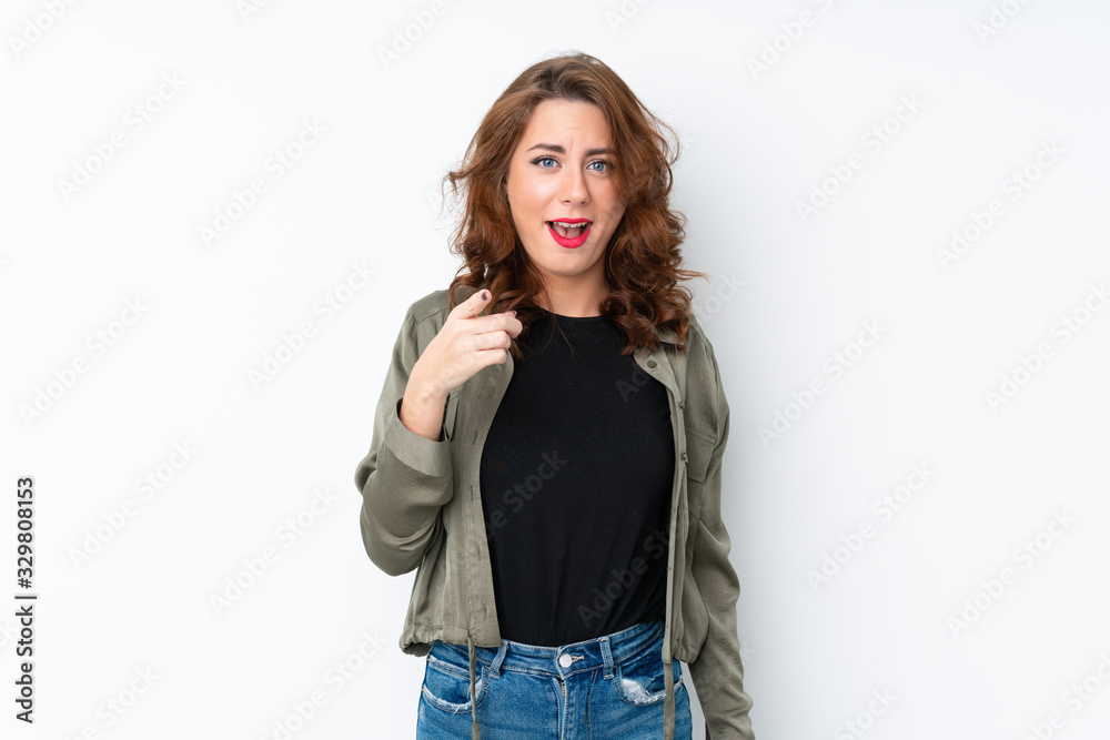 Young Russian woman over isolated white background surprised and pointing front Young Russian woman over isolated white background surprised and pointing front