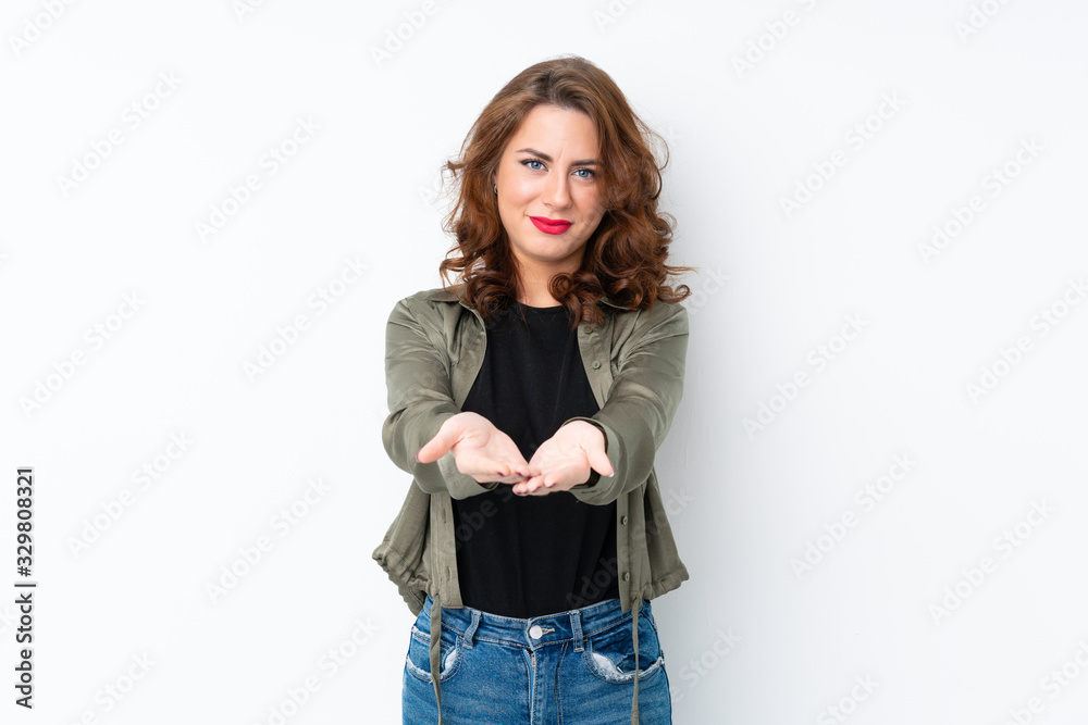 Young Russian woman over isolated white background holding copyspace imaginary on the palm to insert an ad Young Russian woman over isolated white background holding copyspace imaginary on the palm to insert an ad