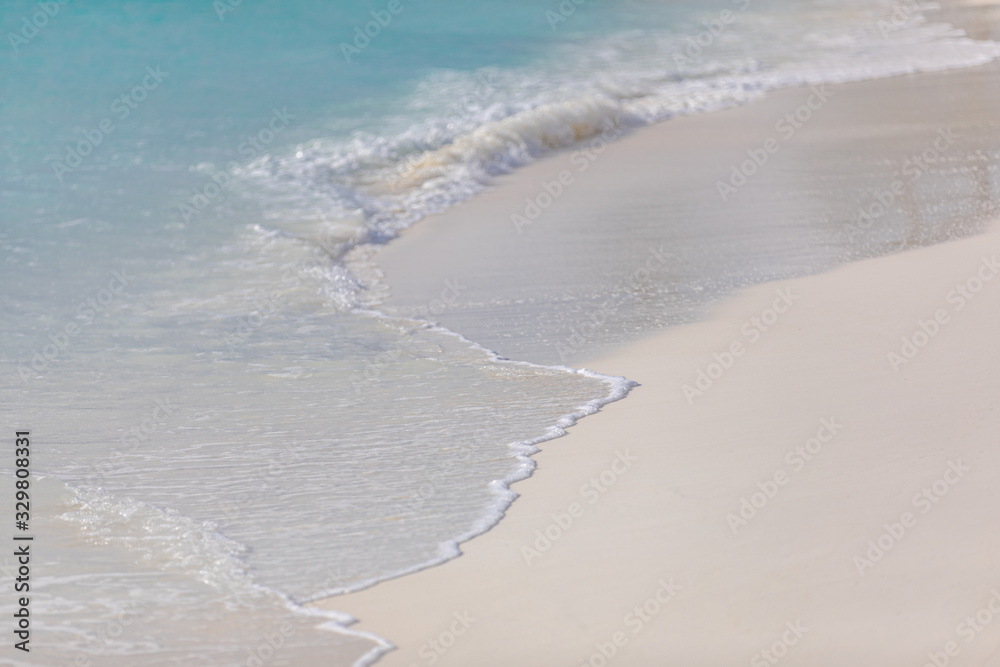 Summer beach and sea, soft waves splashing. Tropical sea, coastline pattern