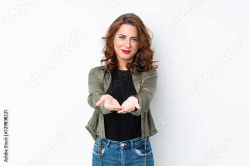 Young Russian woman over isolated white background holding copyspace imaginary on the palm to insert an ad