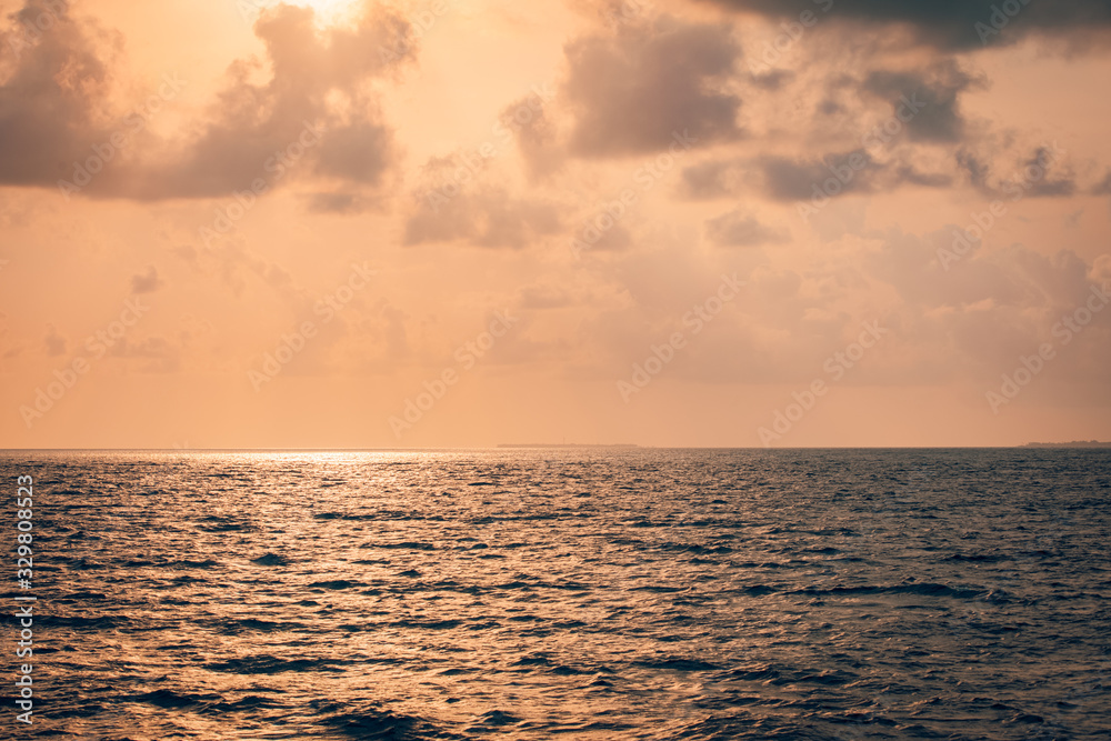 Fototapeta premium Peaceful seascape, tropical sea sunset with orange sky and clouds. Calm sea sunset