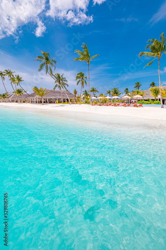 Maldives beach with luxurious water villas and loungers beautiful tropical scene. Luxury summer travel destination background concept. Beach and bay mood for summer vacation or holiday design