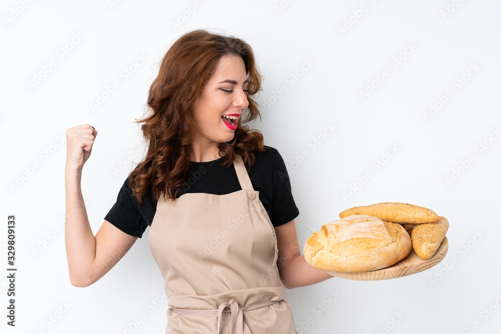 Woman in chef uniform. Female baker holding a table with several breads celebrating a victory Woman in chef uniform. Female baker holding a table with several breads celebrating a victory