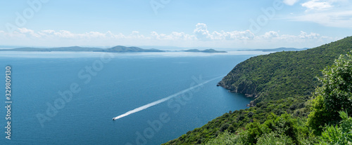 View from the Marmara island over seeing a green hill and a boat in Marmara sea, Turkey photo