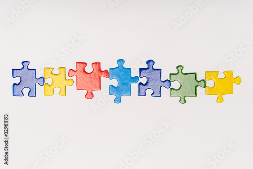 Top view of multicolored pieces of puzzle isolated on white, autism concept