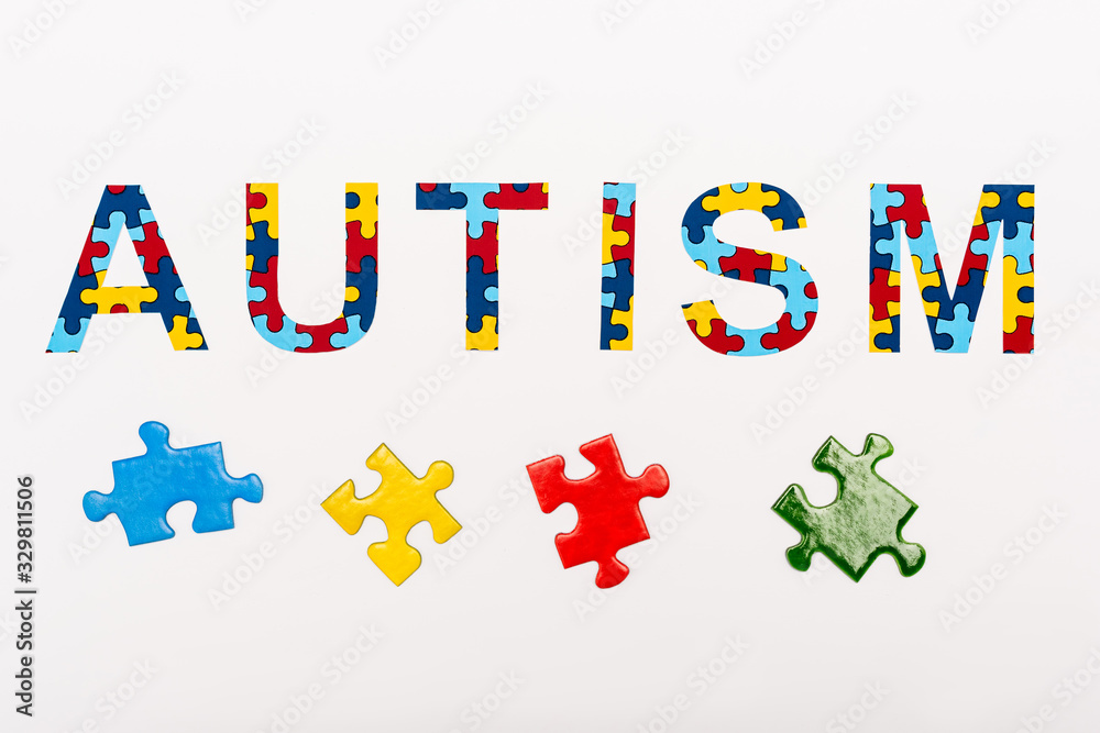 Fototapeta premium Top view of Autism puzzle lettering on white