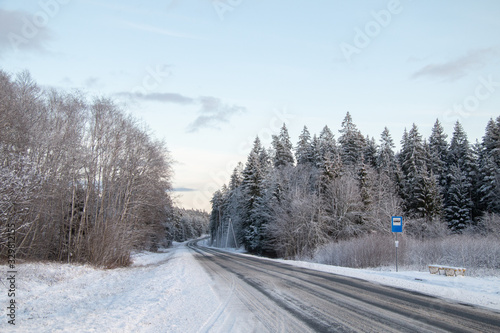 Winter country road and a bus stop in snowy winter day © Zigmar Stein