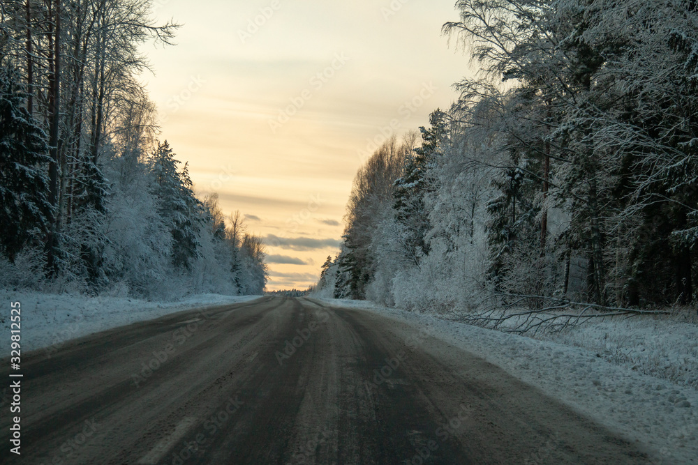 Obraz premium Winter country road in snowy winter day at sunset