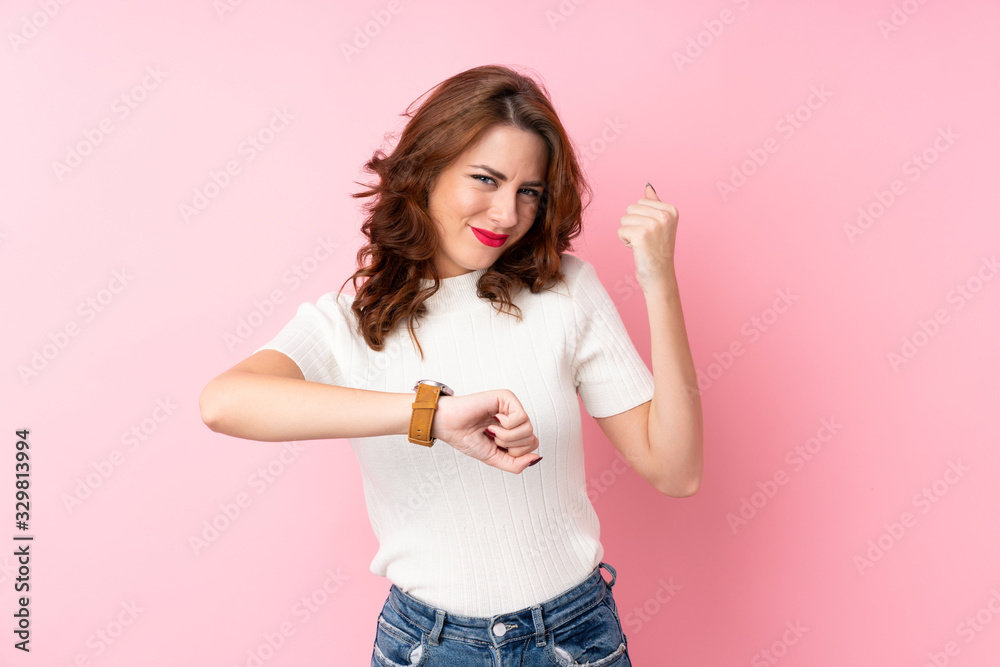 Young Russian woman over isolated pink background with wrist watch and lucky expression Young Russian woman over isolated pink background with wrist watch and lucky expression
