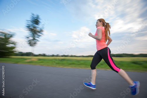 Young woman running outdoors on a lovely sunny winter/fall day (motion blurred image) © lightpoet