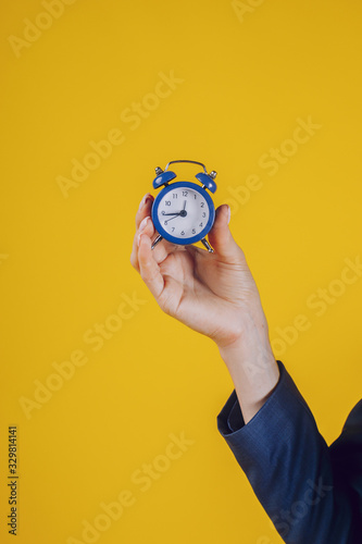 Fototapeta Naklejka Na Ścianę i Meble -  a retro watch held in a lady's palm, on a yellow background