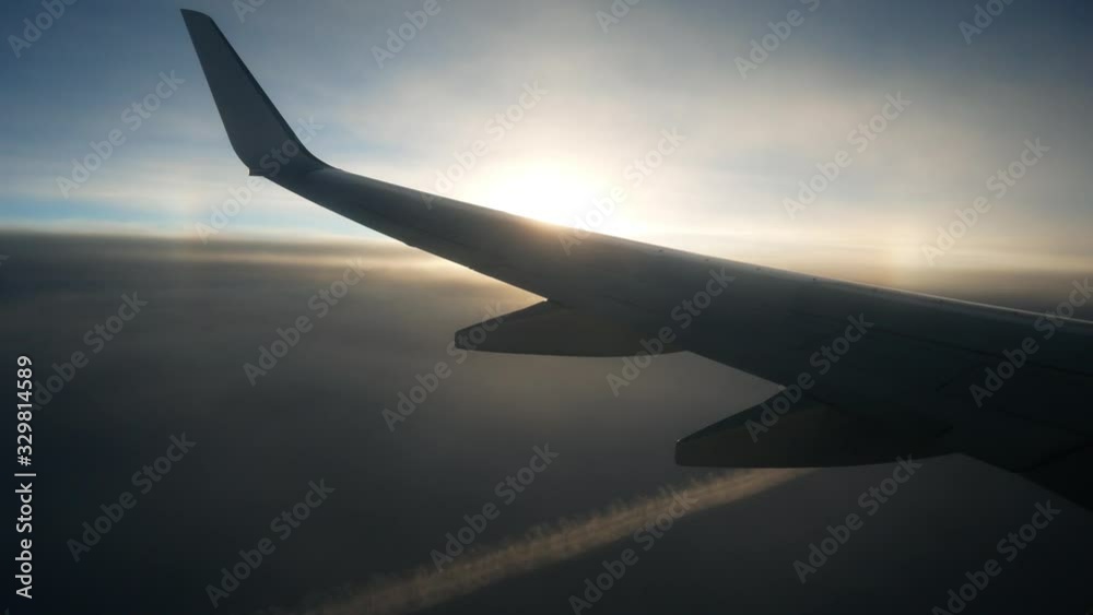 Wing of the plane airplane airliner aircraft in the beautiful sunny morning sky. Aviation tourist flights by air Wing of the plane airplane airliner aircraft in the beautiful sunny morning sky. Aviation tourist flights by air