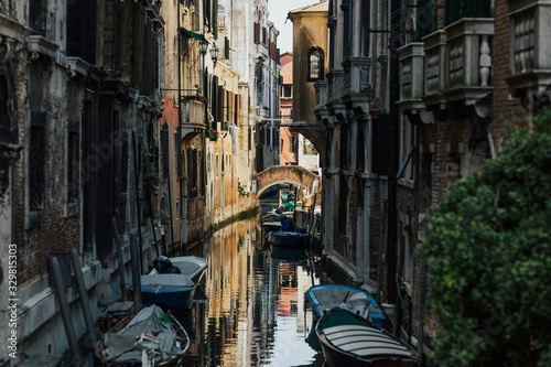 Venice, Italy. Narrow Canal with old houses with parked boats. One of the most famous cities in Italy. It is located on the islands covered by canals and historic bridges. 