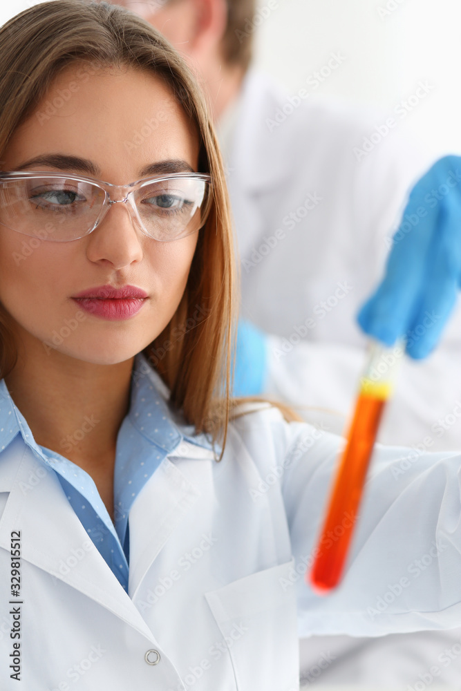 Technician hold in arms in protective gloves sample bottle with poison fluid portrait. Medical worker in uniform use reagent tube for virus infection exam water biological toxic reaction drug creation Technician hold in arms in protective gloves sample bottle with poison fluid portrait. Medical worker in uniform use reagent tube for virus infection exam water biological toxic reaction drug creation