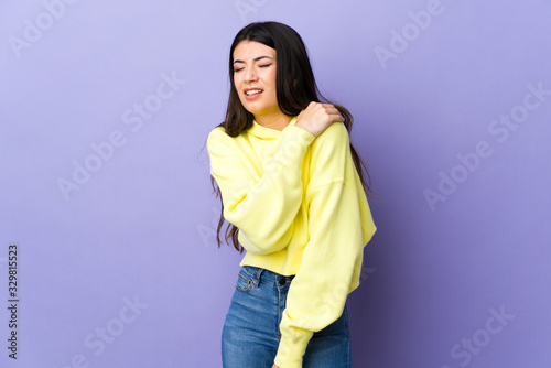 Young brunette woman over isolated purple background suffering from pain in shoulder for having made an effort © luismolinero