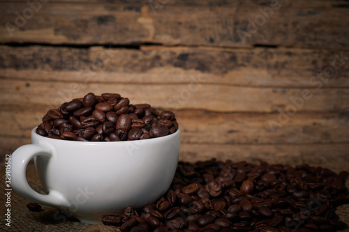 Coffee beans in a cup on a wooden table