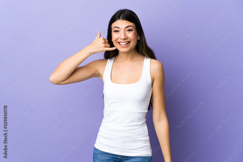 Young brunette woman over isolated purple background making phone gesture. Call me back sign Young brunette woman over isolated purple background making phone gesture. Call me back sign