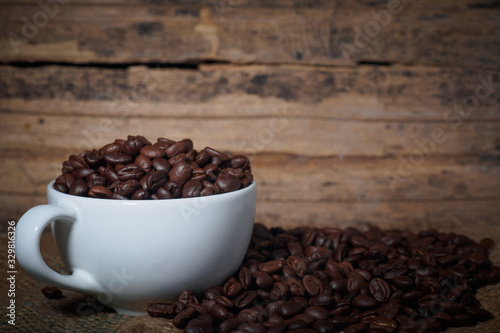 Coffee beans in a cup on a wooden table