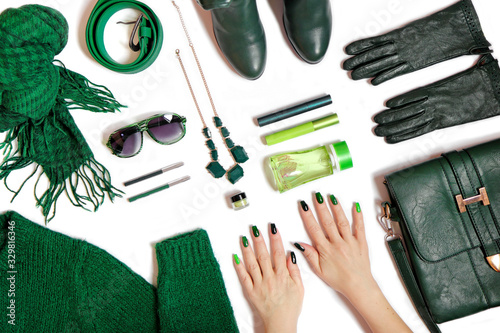 Fashionable green manicure on long nails and women's accessories in various shades of green on a white background.