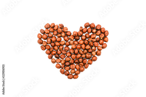 Heart shape made of nuts. Brown hazelnut kernels on a white background.