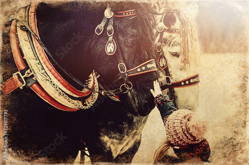 Naklejka child stroking work horse, old photo effect.