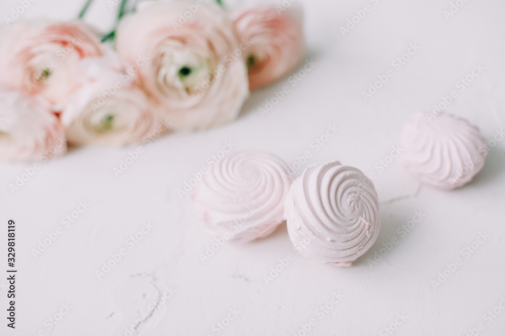Spring wallpaper. Pink rose flowers and marshmallows on a white background. Flowers composition. Flat lay, top view, copy space. Spring wallpaper. Pink rose flowers and marshmallows on a white background. Flowers composition. Flat lay, top view, copy space.