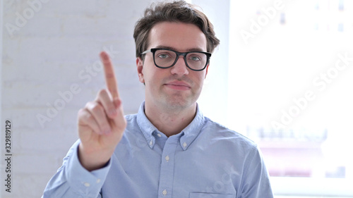 Portrait of Serious Young Businessman saying No with Finger Sign