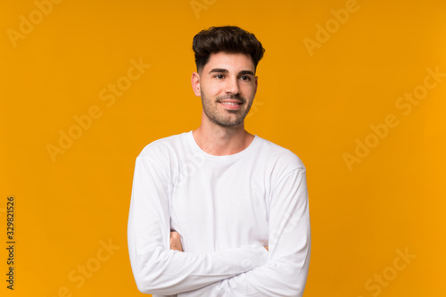 Young man over isolated orange background with confuse face expression