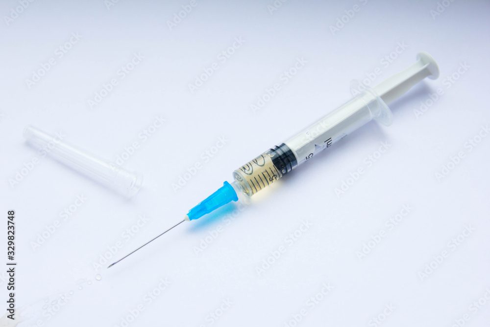 An opened syringe with a vaccine at white background An opened syringe with a vaccine at white background