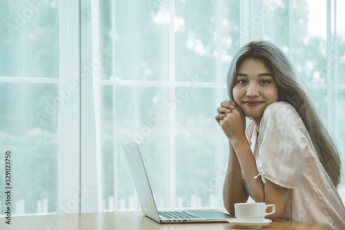 Lazy bored asian woman using laptop in the morning.