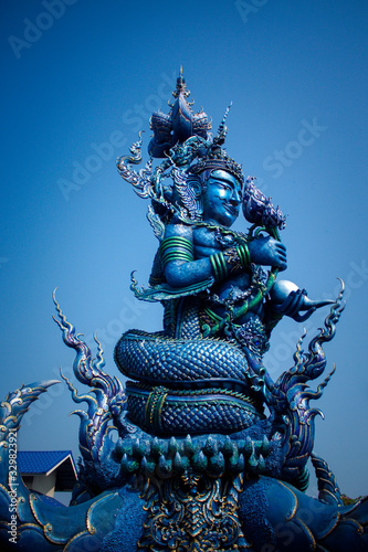 A blue statue with a kettle in hand at Blue temple.