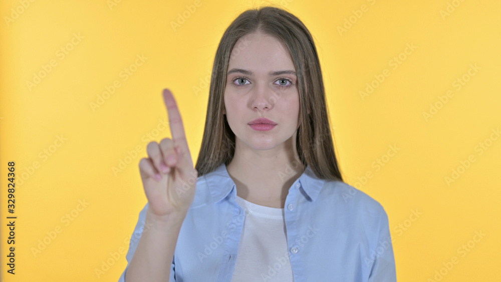 Casual Young Woman saying No with Finger Sign, Yellow Background Casual Young Woman saying No with Finger Sign, Yellow Background