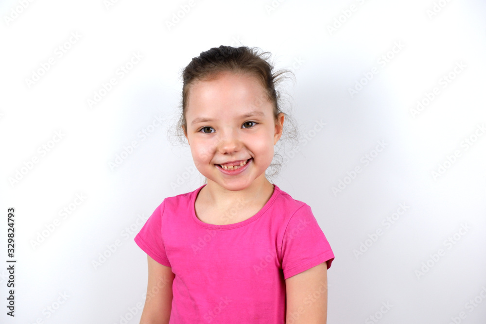 Cheerful cute caucasian little preschooler girl in a pink T-shirt smiles with a fallen milk tooth looking at the camera. Childhood, happiness, joy, child dentistry, goods and services for children Cheerful cute caucasian little preschooler girl in a pink T-shirt smiles with a fallen milk tooth looking at the camera. Childhood, happiness, joy, child dentistry, goods and services for children