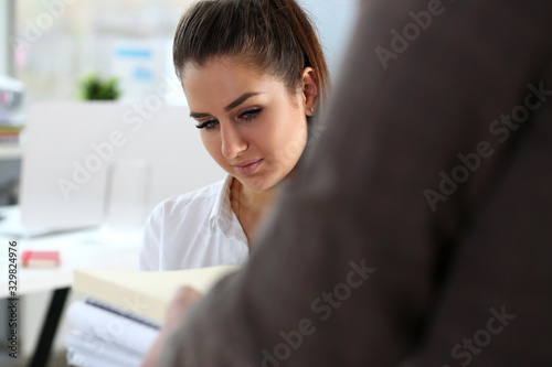 Male worker show pack of papers to busy beautiful female clerk in office portrait. hold in hand pile paper folders workaholic sad exhausted tired accept career request concept