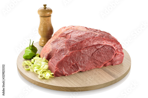 Raw topside beef or part of the round steak, ready to be cooked. On a cutting board with leek and peppers aside, isolated on white background photo