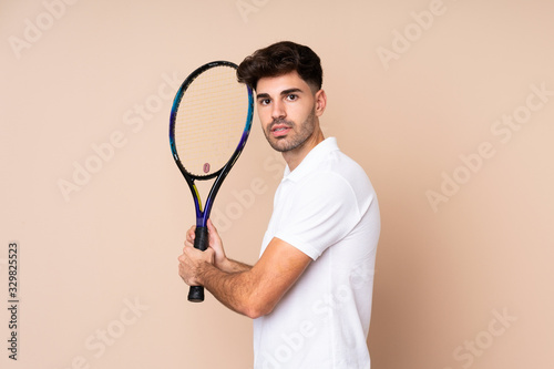 Young man over isolated background playing tennis © luismolinero