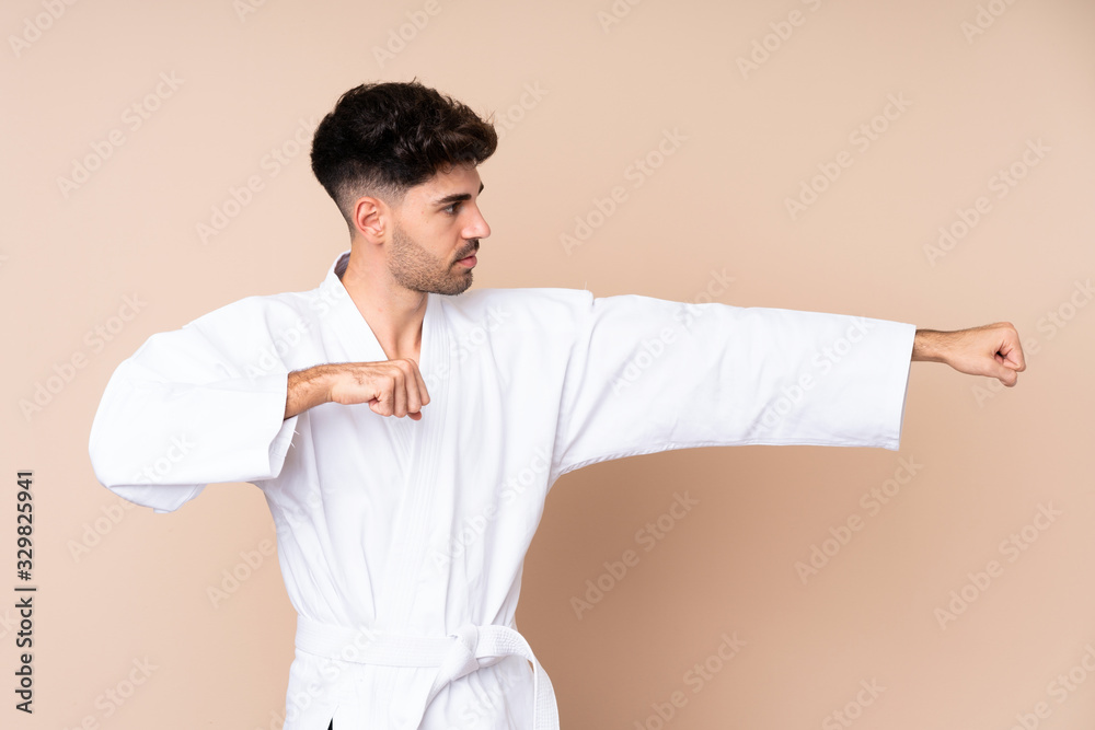 Young man over isolated background doing karate Young man over isolated background doing karate