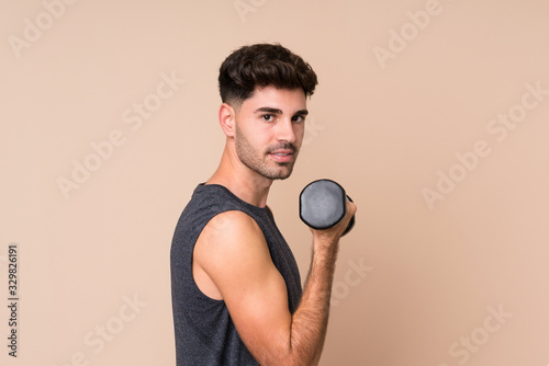 Young sport man over isolated background making weightlifting