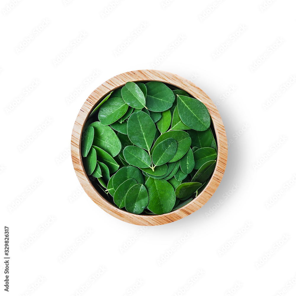 Moringa oleifera leaf in cup wood isolated on a white background. Moringa oleifera leaf in cup wood isolated on a white background.