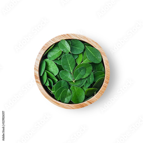 Moringa oleifera leaf in cup wood isolated on a white background. photo