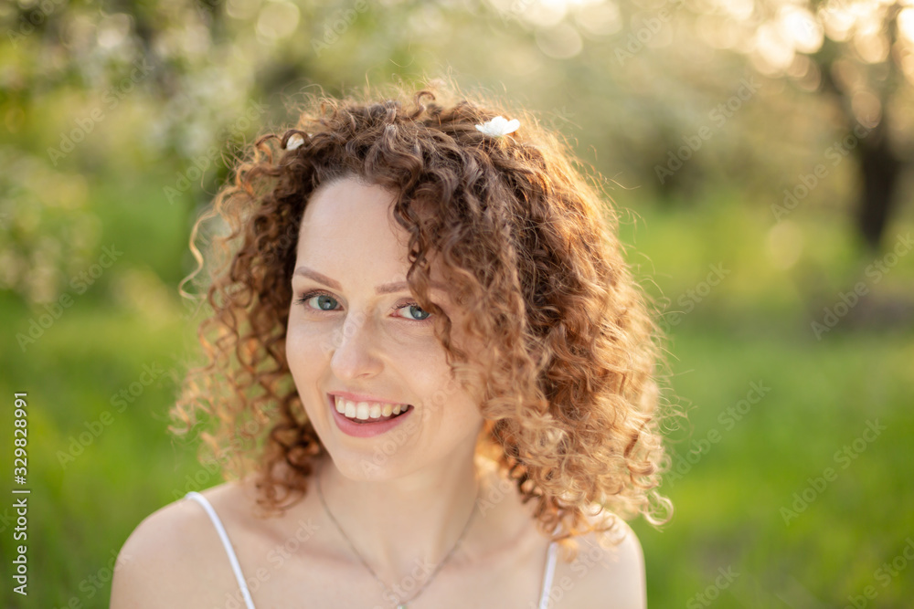 Close up portrait of young smiling attractive woman with curly hair in green flowering spring park. Pure emotions. Close up portrait of young smiling attractive woman with curly hair in green flowering spring park. Pure emotions.