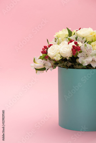 bouquet of flowers in turquoise gift box on pink background