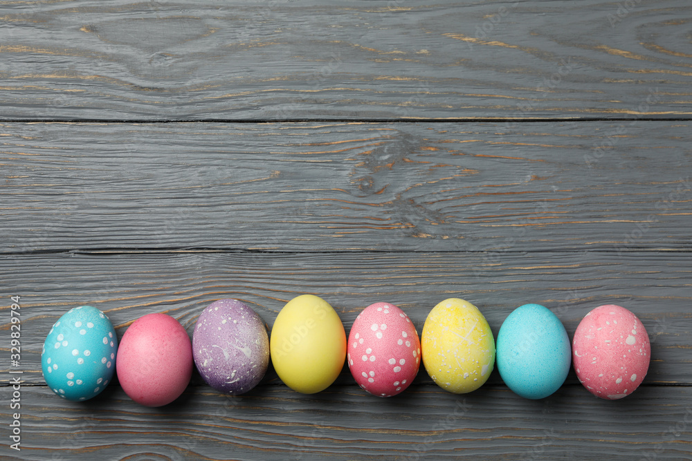 Multicolor Easter eggs on wooden grey background, space for text Multicolor Easter eggs on wooden grey background, space for text