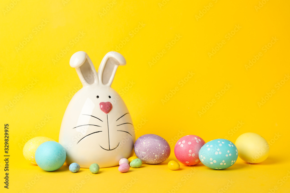 Bunny and Easter eggs on yellow background, space for text