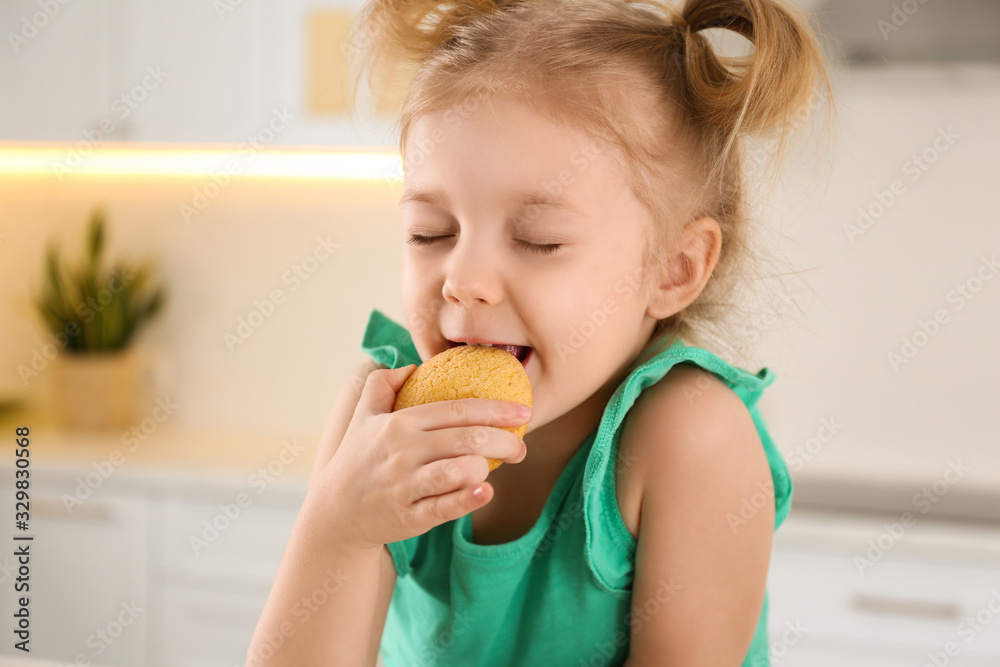 Cute little girl eating cookies in kitchen Cute little girl eating cookies in kitchen
