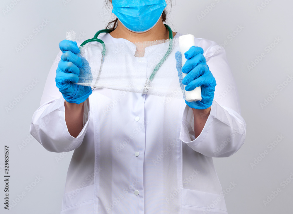 medic woman in white coat and mask holds a twisted gauze bandage medic woman in white coat and mask holds a twisted gauze bandage