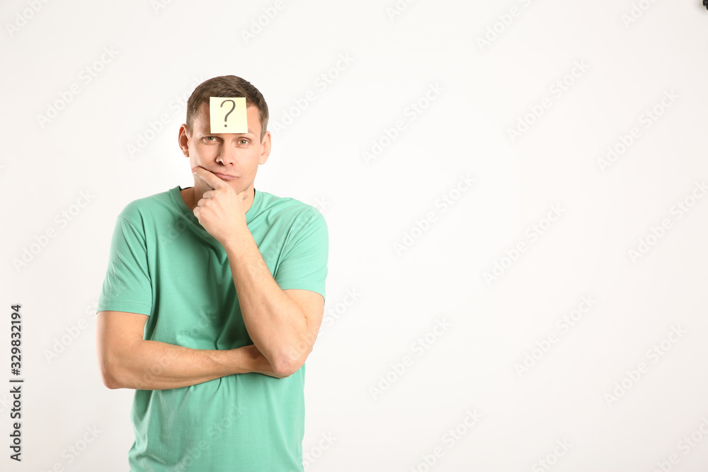 Fototapeta premium Thoughtful man with question mark on white background