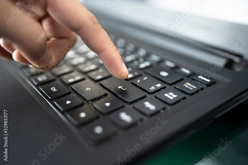 Man's finger finger press enter button. closeup of male hand typing on keyboard